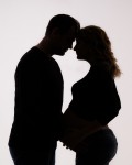 silueta buducich rodicov pri tehotenskom foteni na bielom pozadi